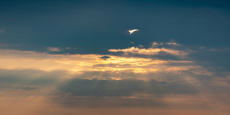 sun beams bursting through dark clouds