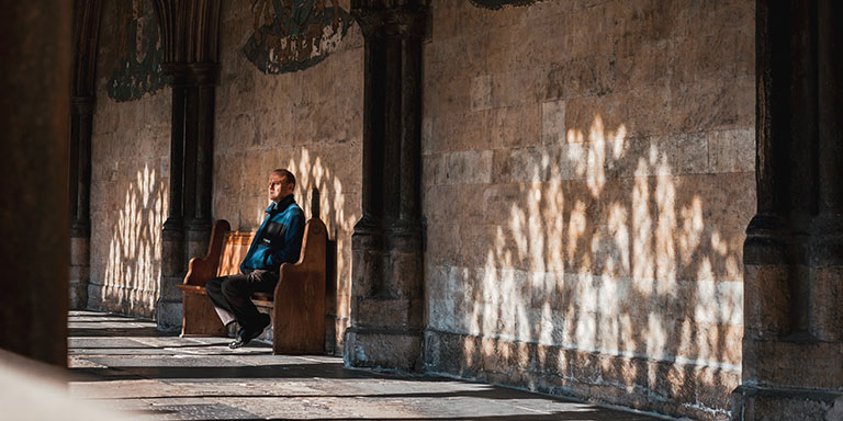 man sitting on pew in old church
